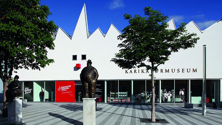 Museum mit weißem Gebäude und Skulptur vor der Tür