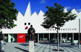 Museum mit weißem Gebäude und Skulptur vor der Tür